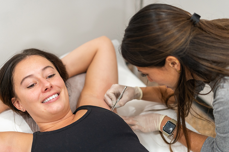 Body wax esthetician performing body wax service